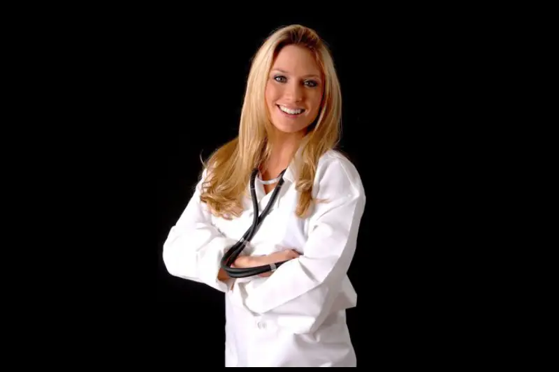 A woman in white lab coat with arms crossed.