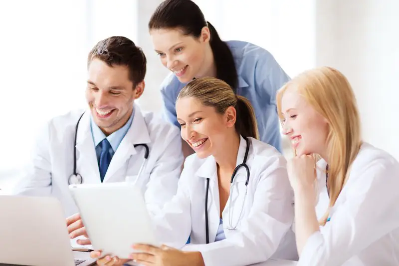 A group of doctors looking at something on a tablet.